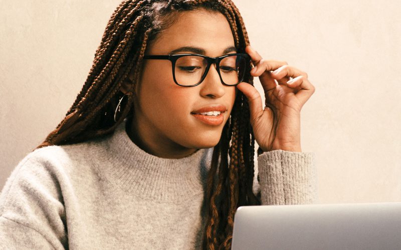 Woman wearing glasses looking down at computer