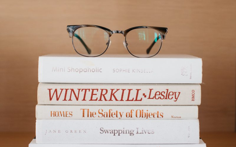 Kepler Browline Glasses in Tortoise on a stack of books