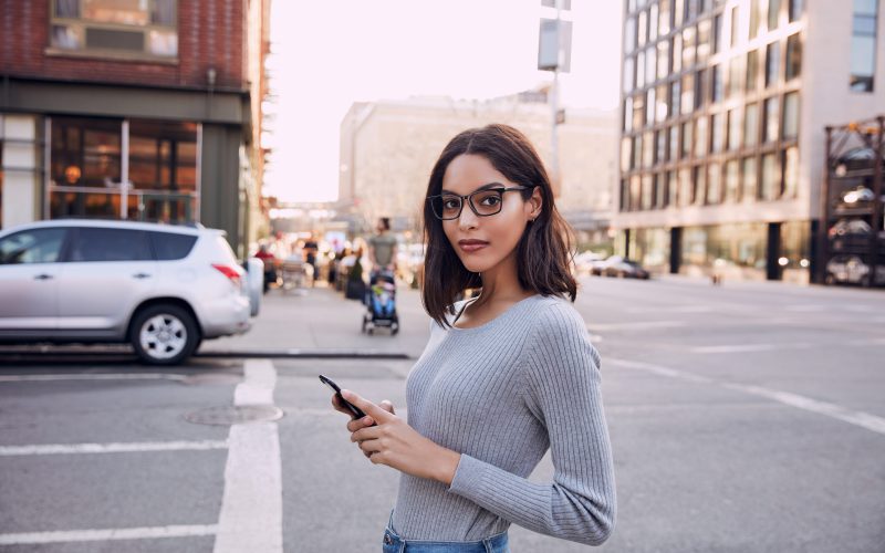 Woman crossing the street with phone wearing Felix Gray blue light glasses