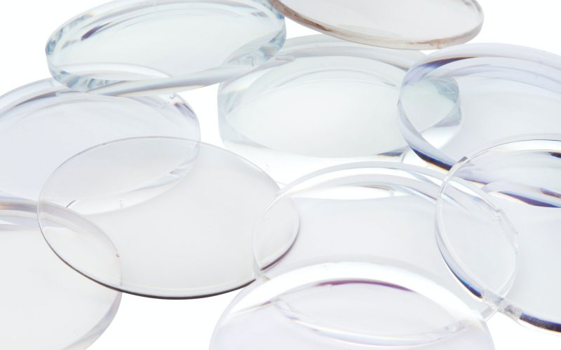 A pile of clear eyeglass lenses