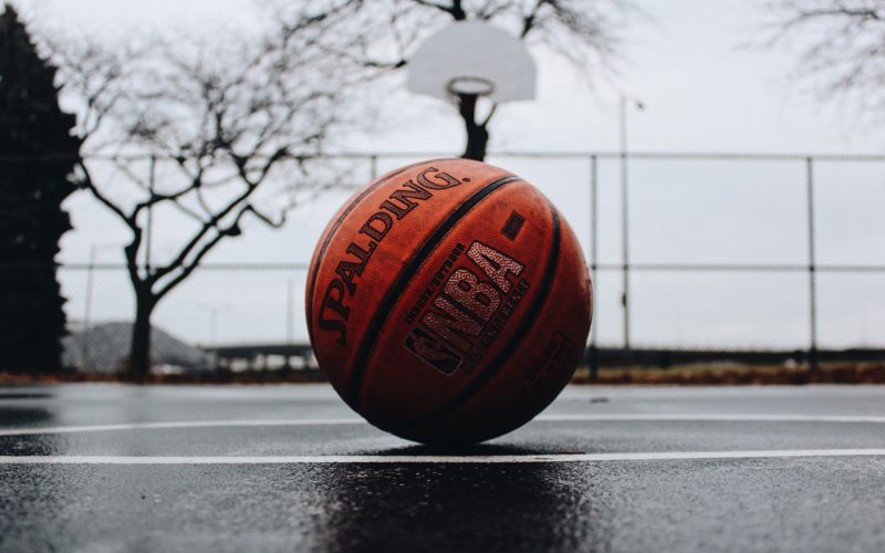 Basketball on a court with a hoop in the background